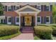 Close-up of the front entrance featuring a yellow door, brick walkway, and manicured bushes at 3287 Alton Rd, Atlanta, GA 30341