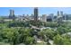 Aerial view showcases a home surrounded by mature trees, and the city skyline at 3809 Wieuca Ne Rd, Atlanta, GA 30342
