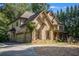 Beautiful two-story stone and brick home featuring a front porch and attached garage at 3809 Wieuca Ne Rd, Atlanta, GA 30342