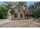 Charming stone and brick home featuring detailed shutters, lush landscaping, and a circular driveway at 3809 Wieuca Ne Rd, Atlanta, GA 30342