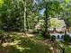 View of home from backyard featuring a fire pit, pool, and lush landscaping at 530 Twinflower Ct, Roswell, GA 30075