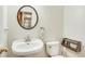 Clean and simple bathroom with a pedestal sink, white toilet, and decorative wall fixtures at 530 Twinflower Ct, Roswell, GA 30075