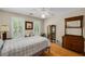 Bedroom with wooden floors, ceiling fan, shutters, and a decorative cabinet at 530 Twinflower Ct, Roswell, GA 30075