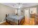 Bedroom with wood flooring, ceiling fan, shutters, and ensuite bathroom at 530 Twinflower Ct, Roswell, GA 30075