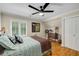 Bedroom with hardwood floors, ceiling fan, and window with plantation shutters, and neutral walls at 530 Twinflower Ct, Roswell, GA 30075