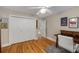 Bedroom with hardwood floors, double bi-fold closet doors, and an adjacent desk area at 530 Twinflower Ct, Roswell, GA 30075