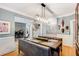 Dining area with hardwood floors, stylish light fixture, open to the living room and stairs at 530 Twinflower Ct, Roswell, GA 30075