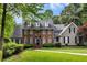 Beautiful two story brick home with dormer windows and lush green landscaping at 530 Twinflower Ct, Roswell, GA 30075