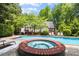 Heated in-ground pool and hot tub with home in background create ideal outdoor entertainment area at 530 Twinflower Ct, Roswell, GA 30075