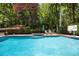 Sparkling pool and hot tub surrounded by trees and greenery create a private backyard oasis at 530 Twinflower Ct, Roswell, GA 30075