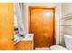 Powder room featuring a wood door and an updated sink and toilet at 1176 Cardinal Ne Rd, Conyers, GA 30012