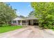 Charming single-story home with a gray brick facade, mature trees and a carport at 1176 Cardinal Ne Rd, Conyers, GA 30012