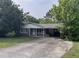 Lovely single-story home featuring a covered parking area, a neat front yard, and beautiful surrounding trees at 1176 Cardinal Ne Rd, Conyers, GA 30012