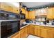 Well-lit kitchen features wood cabinets, black appliances, and white countertops at 1176 Cardinal Ne Rd, Conyers, GA 30012