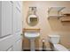 Powder room with pedestal sink, round mirror, open shelving, and tile flooring at 2595 Glaramara Ter, Cumming, GA 30041