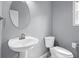 Powder room featuring a pedestal sink, round mirror, and gray walls at 2595 Glaramara Ter, Cumming, GA 30041