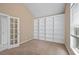 Cozy bedroom with neutral carpet, built-in shelving, and a large window at 2595 Glaramara Ter, Cumming, GA 30041