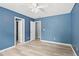 Bright blue room with new flooring, a ceiling fan, and doorways to other rooms at 2595 Glaramara Ter, Cumming, GA 30041