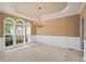 Dining room with tray ceiling, wainscoting, hardwood floors, and large windows at 2595 Glaramara Ter, Cumming, GA 30041