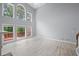 Bright living room with large windows, vaulted ceiling, and wood-look floors at 2595 Glaramara Ter, Cumming, GA 30041