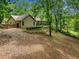 Scenic backyard featuring a lush lawn, mature trees, and a charming wooden fence at 5535 Dorsett Shoals Rd, Douglasville, GA 30135
