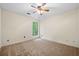 Bedroom with neutral carpet, fan, and window looking out to trees at 5535 Dorsett Shoals Rd, Douglasville, GA 30135