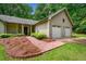 Charming home featuring a brick pathway, attached two-car garage, and lush landscaping at 5535 Dorsett Shoals Rd, Douglasville, GA 30135