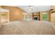 Spacious living room featuring a vaulted ceiling, a stone fireplace, and neutral carpeting at 5535 Dorsett Shoals Rd, Douglasville, GA 30135
