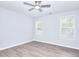 A bright bedroom features a ceiling fan, light walls, two windows, and wood-look flooring at 662 Shady Willow Ln, Loganville, GA 30052