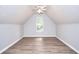 Attic conversion with wood flooring, large window, and peaked ceiling at 662 Shady Willow Ln, Loganville, GA 30052