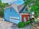 Side view of a blue home with a white garage door, brick accents, and lush greenery at 662 Shady Willow Ln, Loganville, GA 30052