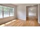 Sunlit living room with hardwood floors, large windows, and an open doorway leading to the dining area at 662 Shady Willow Ln, Loganville, GA 30052