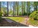 Large backyard with mature trees and a stone path leading to a seating area and firepit at 1691 Whitlock Rd, Marietta, GA 30066