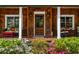 Inviting front porch with wood columns and colorful flowers in the foreground, and seating on the porch at 1691 Whitlock Rd, Marietta, GA 30066