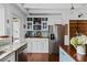 Well-lit kitchen with stainless steel refrigerator, granite countertops, wood floors and ample storage space at 1691 Whitlock Rd, Marietta, GA 30066