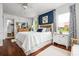Bedroom featuring a white quilt bed, blue paneled accent wall, hardwood floors and natural lighting at 1691 Whitlock Rd, Marietta, GA 30066