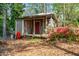 Charming outbuilding with covered porch and red door, surrounded by natural landscaping at 1691 Whitlock Rd, Marietta, GA 30066