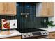 Modern kitchen features a stainless steel stove, white countertops, and a dark tile backsplash with a gold pot filler faucet at 2001 Swazey Dr, Decatur, GA 30032