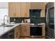 Modern kitchen features stainless steel appliances, light wood cabinets with gold hardware, white countertops, and a dark tile backsplash at 2001 Swazey Dr, Decatur, GA 30032