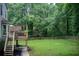 A large deck overlooks backyard with lush lawn and wooden fence at 1360 Stampmill Way, Lawrenceville, GA 30043
