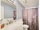Bright bathroom featuring a large mirror, white marble vanity, and shower with a patterned curtain at 1360 Stampmill Way, Lawrenceville, GA 30043