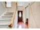 View of foyer with hardwood floors, staircase, and decorative sliding barn door at 1360 Stampmill Way, Lawrenceville, GA 30043