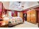 Spacious main bedroom with red walls, tray ceiling and ceiling fan, providing comfort and style at 1360 Stampmill Way, Lawrenceville, GA 30043