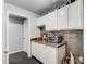 Charming wet bar features ample counter space, sleek white cabinets, and a textured backsplash at 1360 Stampmill Way, Lawrenceville, GA 30043