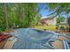 Large backyard with mature trees, a pool under cover and stairs to a deck above at 1620 Cedar Hl, Douglasville, GA 30134