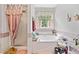 Bright bathroom with a separate shower and soaking tub. Features a large window with privacy curtain at 1620 Cedar Hl, Douglasville, GA 30134