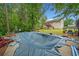 Backyard featuring an in-ground pool covered for the off-season surrounded by lush trees at 1620 Cedar Hl, Douglasville, GA 30134