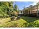 Large backyard with mature trees and patio area with seating for outdoor entertainment at 3055 Henderson Mill Rd, Atlanta, GA 30341