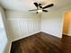 Comfortable bedroom with ceiling fan, window view and paneled wall detail over hardwood floors at 107 Oconnor Dr, Dallas, GA 30157