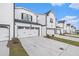 A row of townhouses with white exteriors, attached garages, concrete driveways, and neatly landscaped lawns at 1704 Hyssop Se Blvd, Smyrna, GA 30126